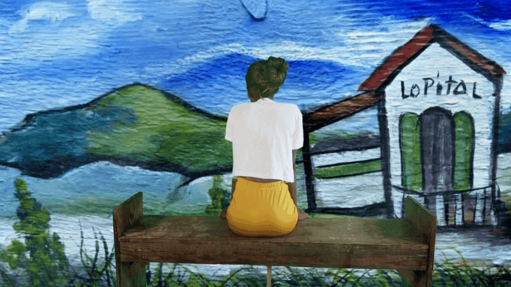 A woman sitting at a bench facing a mural of a colorful landscape with her back to the viewer.