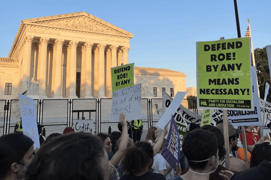 A group of protestors holding signs in front of the US Supreme Court Building