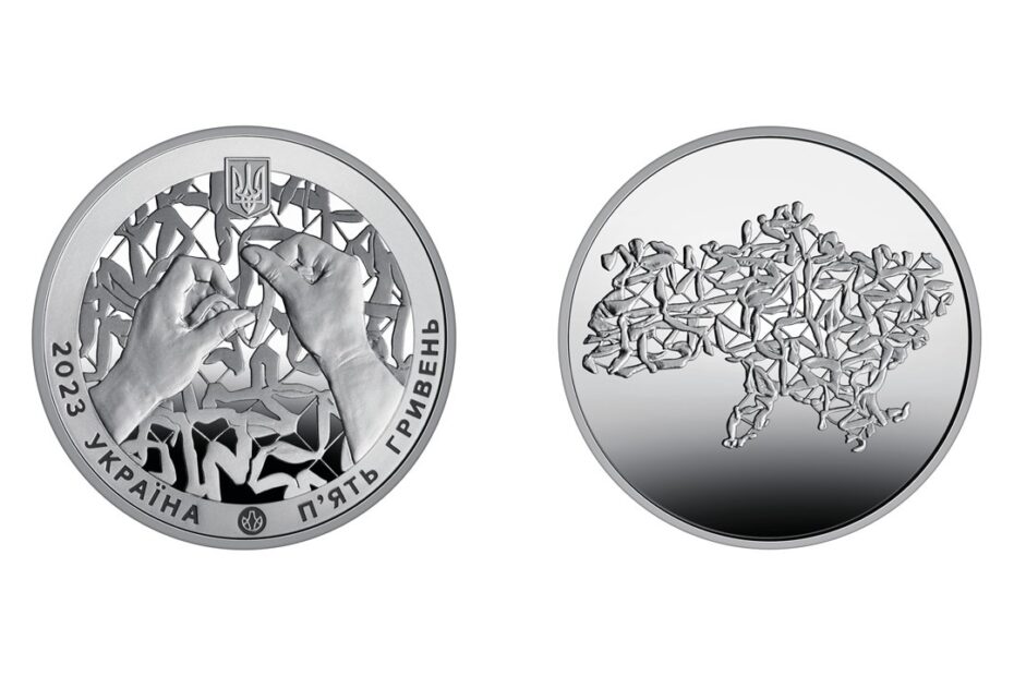 The front and back sides of a silver coin. One side depicts hands weaving a camouflage net, and the other depicts a camouflage net in the shape of Ukraine.